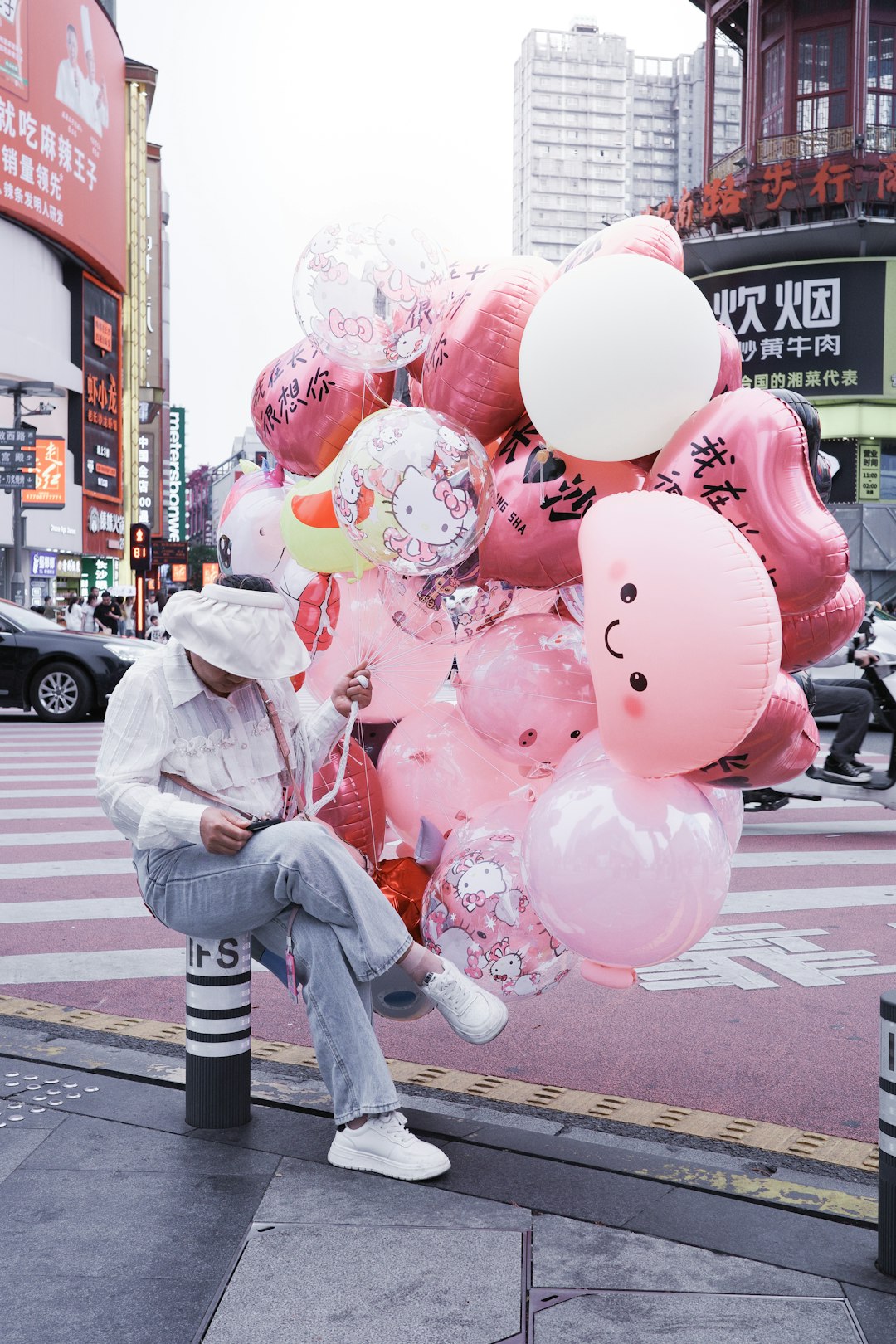 Person with pink balloons on city street